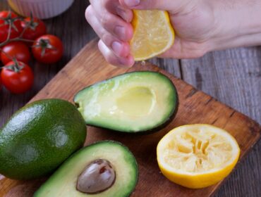man,hand,squeezing,lemon,on,avocado.