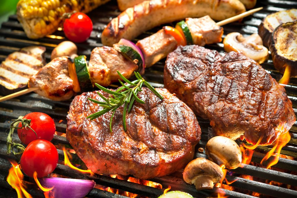 assorted,delicious,grilled,meat,with,vegetables,over,the,coals,on