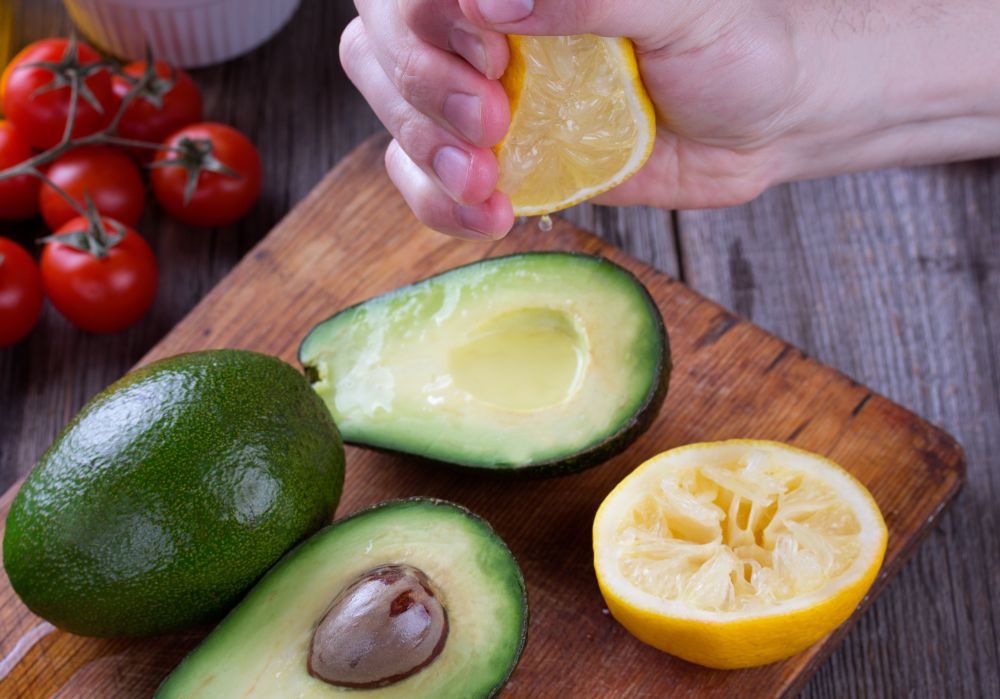 man,hand,squeezing,lemon,on,avocado.